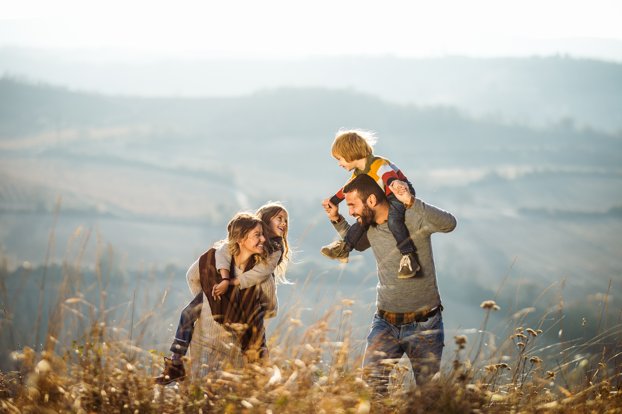 Carefree parents having fun with their kids on a field.